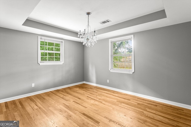 125 Sycamore Dr, Athens, GA 30606 - empty room with light wood-style floors, a tray ceiling, and a chandelier
