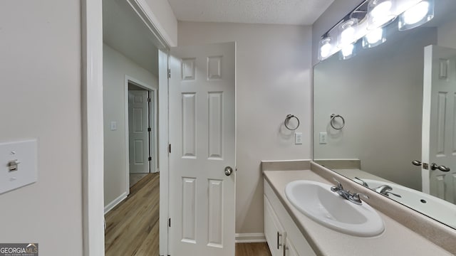 700 Patriots Point St, Locust Grove, GA 30248 - bathroom with wood finished floors, vanity, a textured ceiling, and baseboards