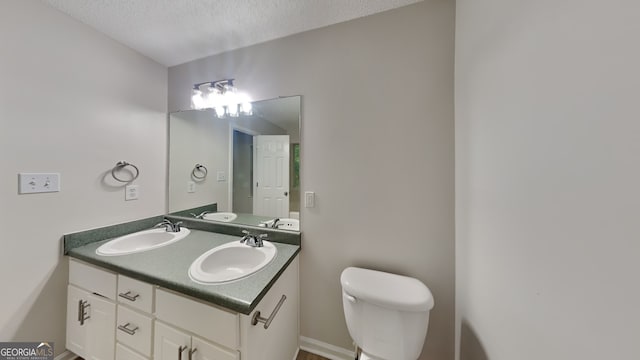 700 Patriots Point St, Locust Grove, GA 30248 - bathroom featuring a textured ceiling, toilet, double vanity, and baseboards