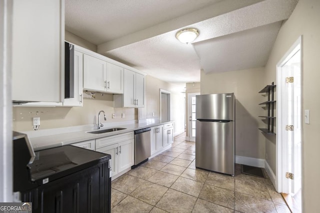 611 Monroe St, Macon, GA 31201 - kitchen featuring appliances with stainless steel finishes, a sink, white cabinetry, light countertops, and a textured ceiling