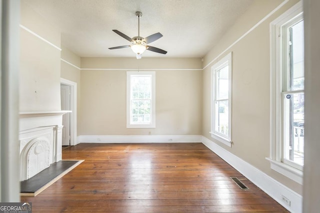 611 Monroe St, Macon, GA 31201 - unfurnished living room featuring plenty of natural light, a ceiling fan, hardwood / wood-style flooring, and a textured ceiling