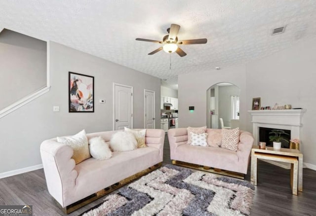 20 Pine Canyon Dr SW Unit 26, Atlanta, GA 30331 - living room with arched walkways, dark wood-style floors, ceiling fan, a textured ceiling, and a fireplace