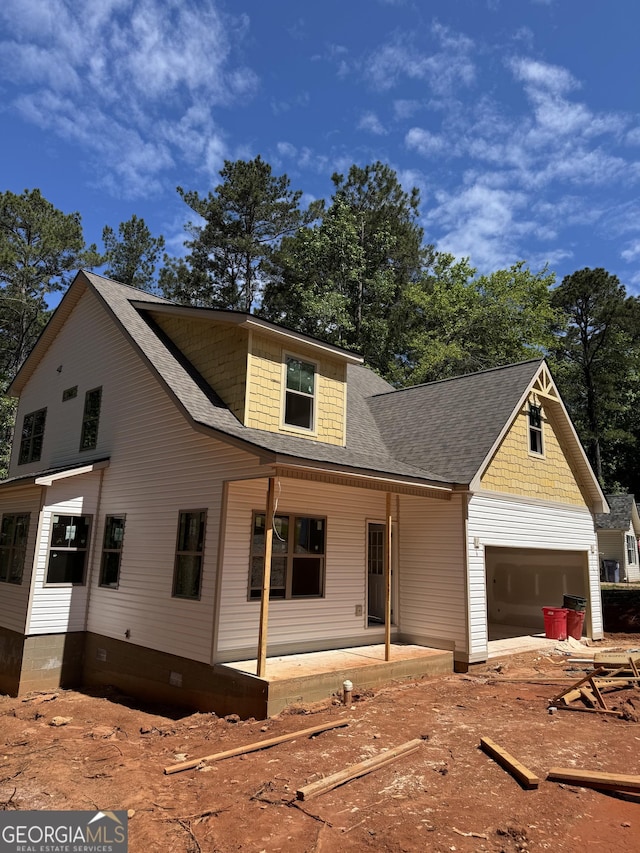 view of front of house with a garage and a shingled roof