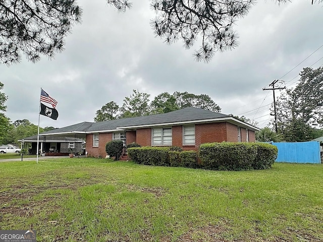ranch-style house featuring a front yard and brick siding