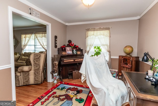 bedroom with light wood-style floors and ornamental molding