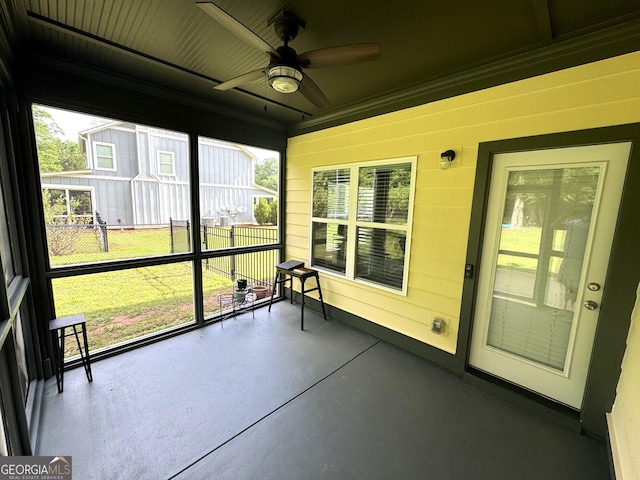 unfurnished sunroom with ceiling fan and plenty of natural light