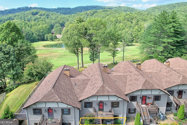 drone / aerial view of a forest and a water and mountain view