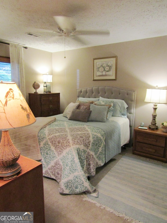 bedroom with a textured ceiling and ceiling fan