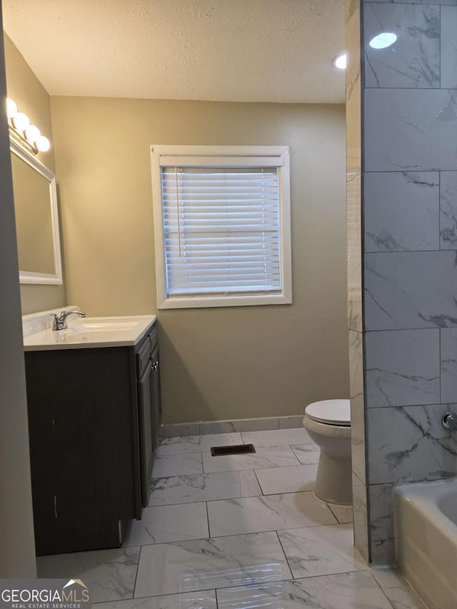 6136 Holiday Blvd, Forest Park, GA 30297 - bathroom featuring marble look tiles, vanity, toilet, baseboards, and a textured ceiling