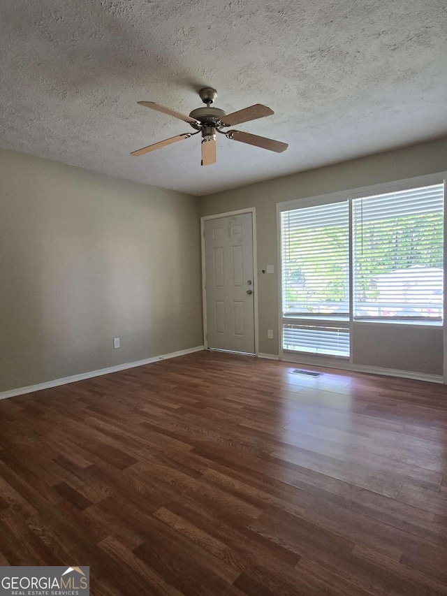 6136 Holiday Blvd, Forest Park, GA 30297 - spare room featuring dark wood-type flooring, baseboards, ceiling fan, and a textured ceiling