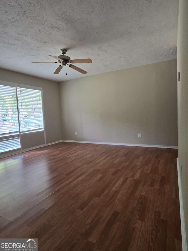6136 Holiday Blvd, Forest Park, GA 30297 - unfurnished room with a textured ceiling, dark wood-style floors, baseboards, and ceiling fan