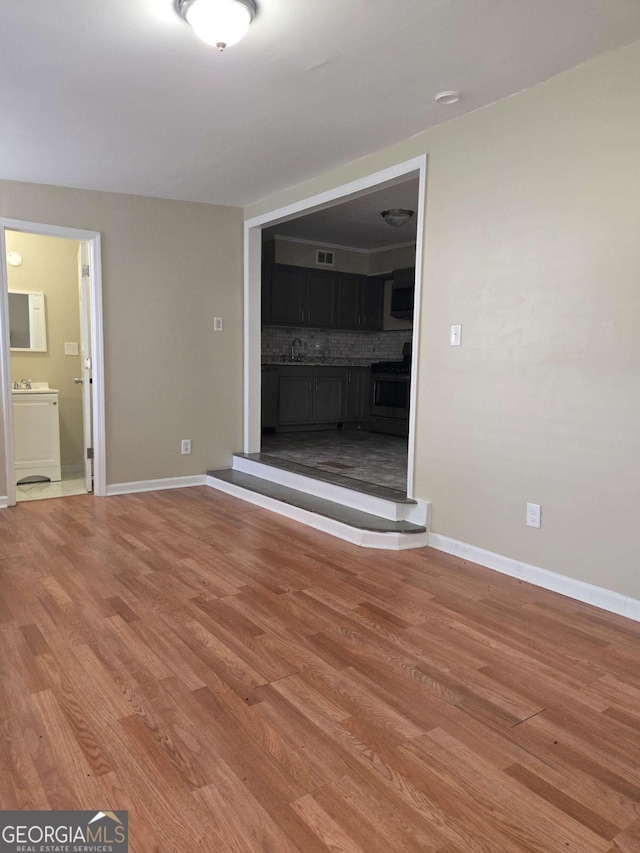 6136 Holiday Blvd, Forest Park, GA 30297 - unfurnished living room with light wood-style floors, baseboards, and a sink