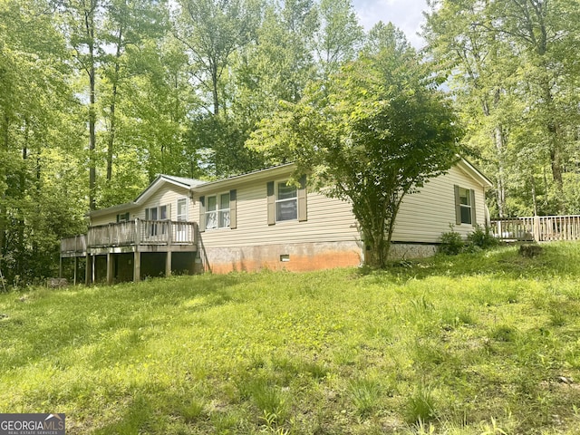 rear view of property featuring a deck and crawl space