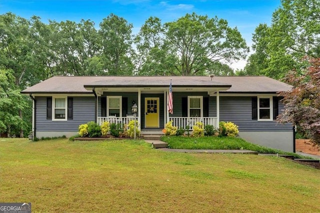 ranch-style house featuring covered porch and a front yard
