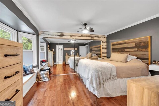 bedroom with ornamental molding and wood finished floors