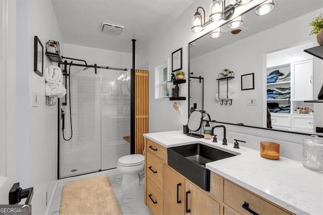 full bath with a shower stall, vanity, marble finish flooring, and toilet