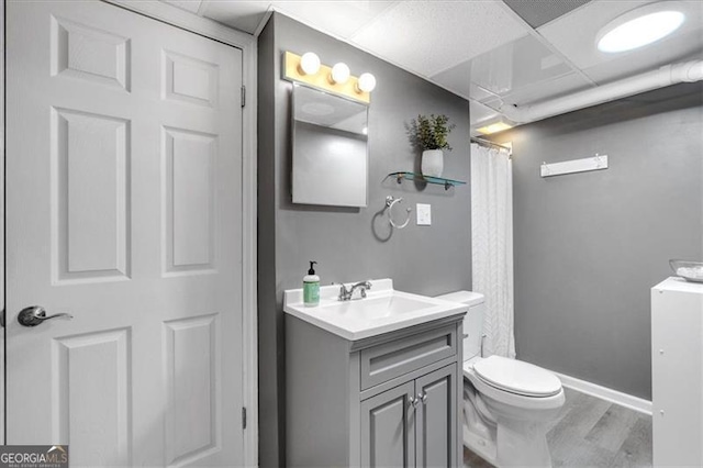 full bath featuring vanity, toilet, wood finished floors, baseboards, and curtained shower