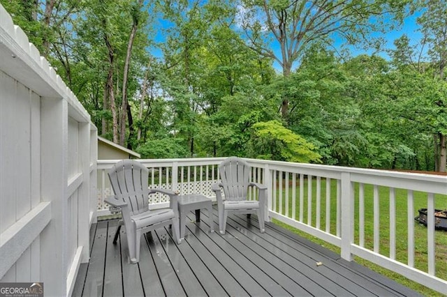 wooden deck with a yard and view of scattered trees
