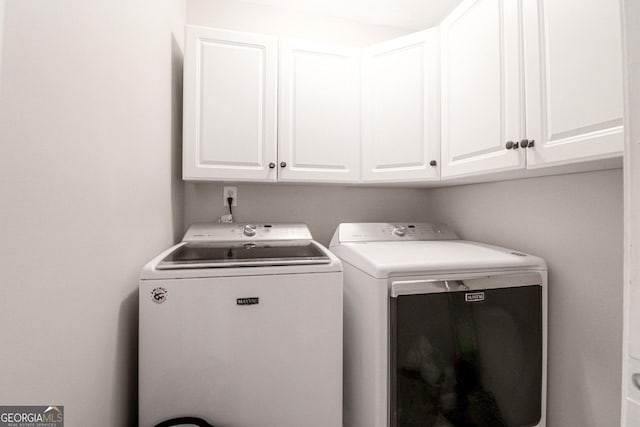 washroom with cabinet space and washer and dryer