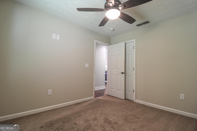 unfurnished bedroom with baseboards, carpet floors, a closet, and ceiling fan