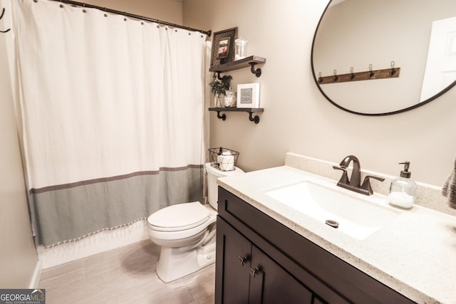 bathroom with toilet, vanity, and a shower with curtain