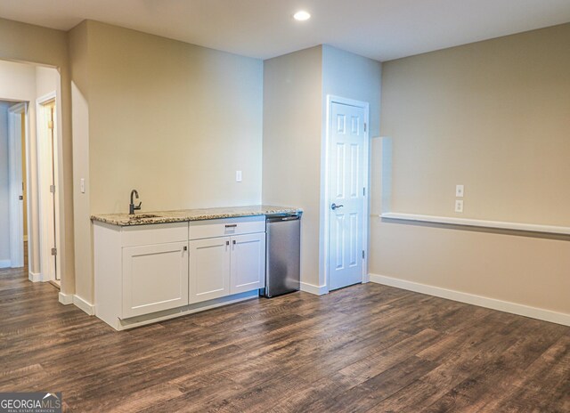 bar area with dark wood finished floors, a sink, recessed lighting, baseboards, and dishwasher