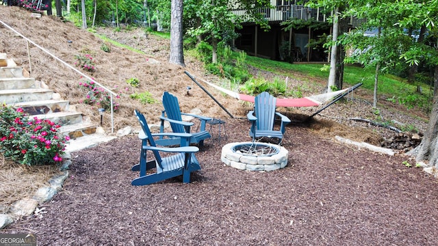 view of yard featuring a fire pit, stairway, and a wooden deck