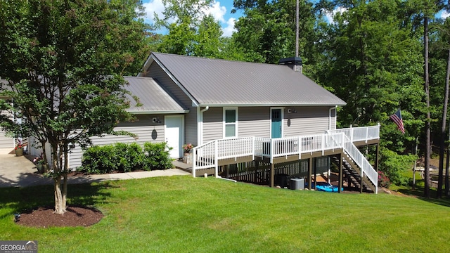 rear view of property featuring stairway, metal roof, a wooden deck, a yard, and central air condition unit