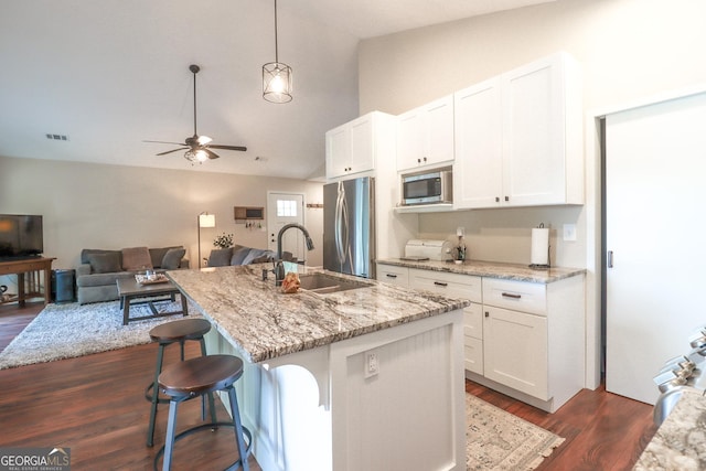 kitchen featuring a sink, stainless steel appliances, white cabinetry, a ceiling fan, and high vaulted ceiling