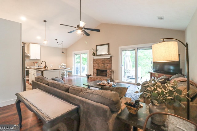 living room featuring dark wood finished floors, a fireplace, a ceiling fan, baseboards, and high vaulted ceiling
