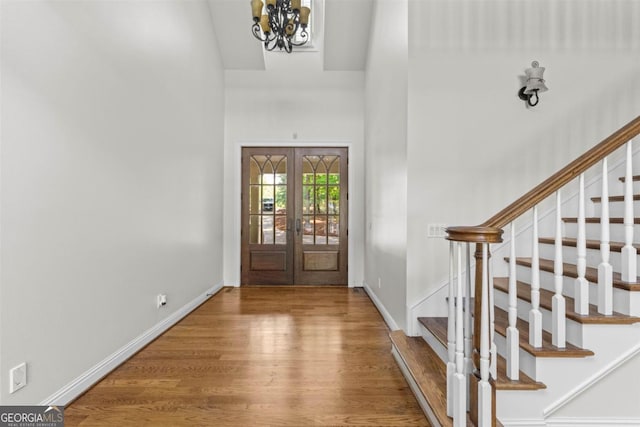 1221 Cosby Cir, Greensboro, GA 30642 - foyer with wood finished floors, stairway, a chandelier, french doors, and a towering ceiling