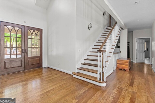 1221 Cosby Cir, Greensboro, GA 30642 - entrance foyer featuring stairway, wood finished floors, french doors, baseboards, and a high ceiling