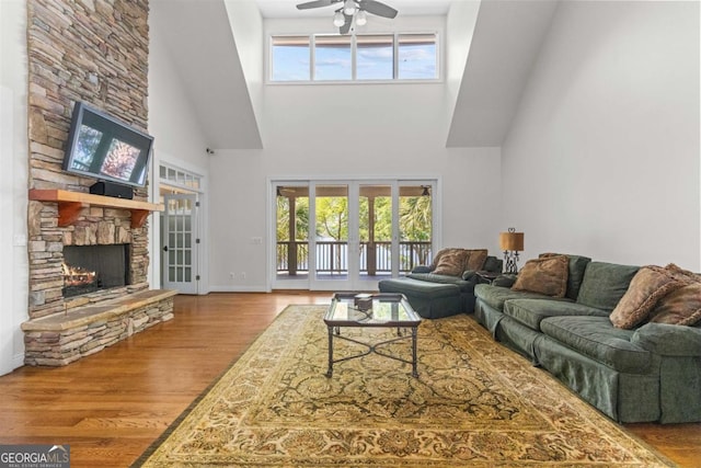 1221 Cosby Cir, Greensboro, GA 30642 - living room with a high ceiling, a fireplace, wood finished floors, ceiling fan, and baseboards