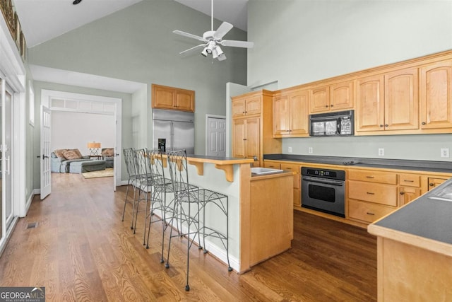 1221 Cosby Cir, Greensboro, GA 30642 - kitchen with stainless steel built in refrigerator, black microwave, wall oven, high vaulted ceiling, and a kitchen bar