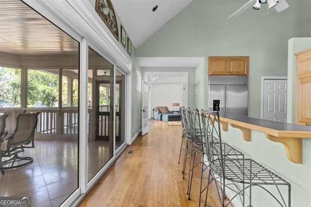1221 Cosby Cir, Greensboro, GA 30642 - kitchen with built in fridge, high vaulted ceiling, a breakfast bar, a ceiling fan, and light wood-style floors