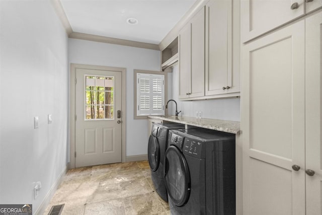 1221 Cosby Cir, Greensboro, GA 30642 - clothes washing area featuring washer and clothes dryer, baseboards, cabinet space, and light stone finish floors