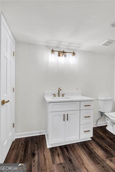 529 Greystone Trl, Marietta, GA 30068 - bathroom with toilet, baseboards, wood finished floors, and vanity