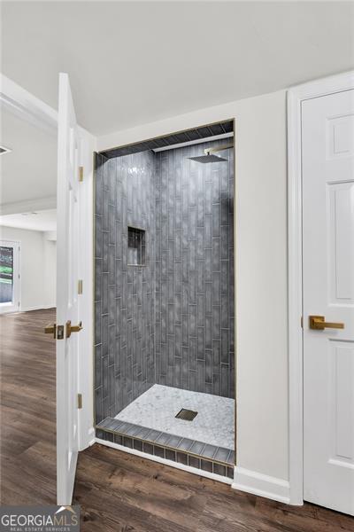 529 Greystone Trl, Marietta, GA 30068 - bathroom featuring tiled shower, wood finished floors, and baseboards
