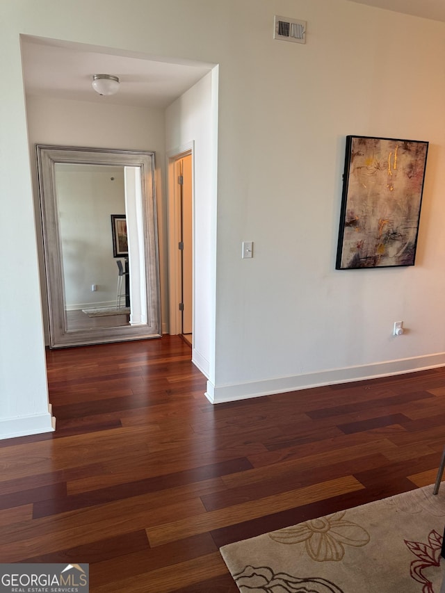hallway featuring wood finished floors and baseboards