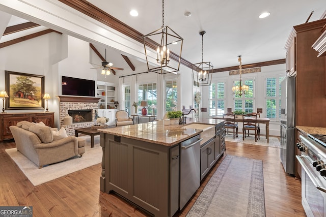 11660 Crabapple Rd, Roswell, GA 30075 - kitchen featuring appliances with stainless steel finishes, a chandelier, gray cabinetry, a brick fireplace, and a ceiling fan