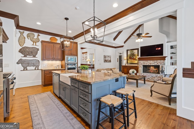 11660 Crabapple Rd, Roswell, GA 30075 - kitchen featuring appliances with stainless steel finishes, a breakfast bar area, light stone counters, recessed lighting, and light wood-style flooring
