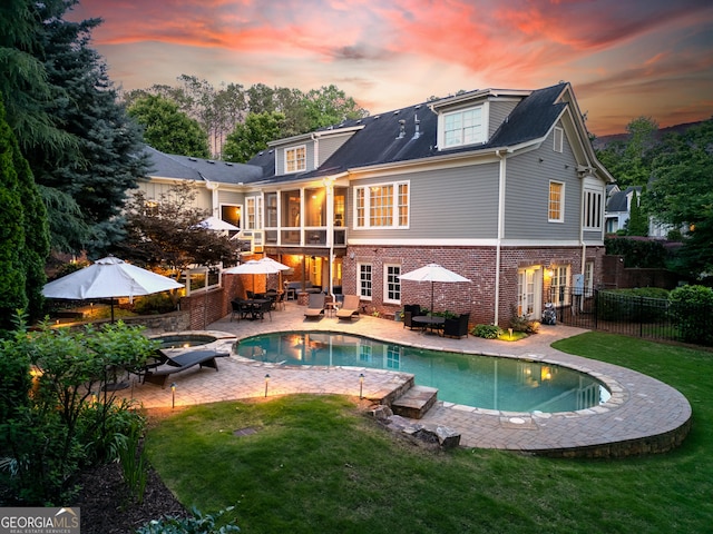 11660 Crabapple Rd, Roswell, GA 30075 - back of house at dusk featuring brick siding, outdoor dining space, a patio, an outdoor pool, and an outdoor living space with a fire pit