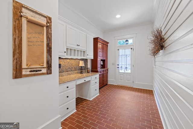 11660 Crabapple Rd, Roswell, GA 30075 - kitchen featuring brick patterned flooring, tasteful backsplash, white cabinetry, built in study area, and light stone counters