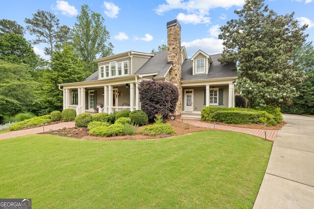 11660 Crabapple Rd, Roswell, GA 30075 - view of front of home with a porch, a front yard, a chimney, and a shingled roof