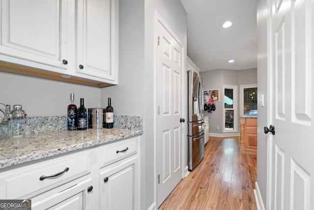 hallway featuring light wood-style flooring, recessed lighting, and baseboards
