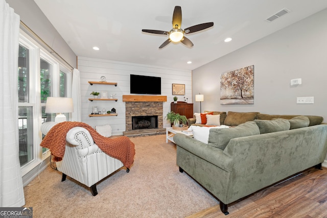 living area featuring ceiling fan, wood finished floors, a stone fireplace, and recessed lighting