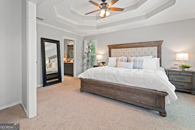 carpeted bedroom with ornamental molding, a raised ceiling, connected bathroom, baseboards, and a ceiling fan