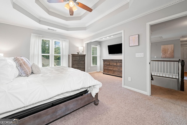 bedroom with ornamental molding, carpet, a raised ceiling, baseboards, and ceiling fan
