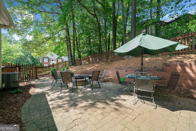 view of patio with outdoor dining area, a fenced backyard, and a fire pit