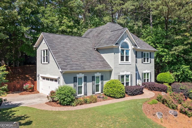 view of front of house with an attached garage, stucco siding, concrete driveway, and roof with shingles